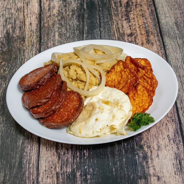 A white plate with fried salami, fried cheese, fried eggs, mangu, and pickled red onions.